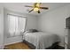 Simple bedroom with a double bed, ceiling fan, and tiled flooring at 20948 N Sansom Dr, Maricopa, AZ 85138