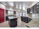 Island kitchen with dark wood cabinets and granite counters at 225 N 236Th Ave, Buckeye, AZ 85396
