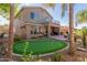 Landscaped backyard with putting green, patio, and palm trees at 2614 W Florimond Rd, Phoenix, AZ 85086