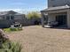 Desert backyard with a covered patio area, grill, outdoor seating, and gravel groundcover at 30770 W Mitchell Dr, Buckeye, AZ 85396