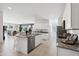 Open kitchen with white cabinets, granite island, and stainless steel appliances at 38130 W Bello Ln, Maricopa, AZ 85138