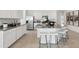 Open concept kitchen with white cabinets, granite island and stainless steel appliances at 38130 W Bello Ln, Maricopa, AZ 85138