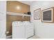 Laundry room with white washer and dryer, and accent wall at 38130 W Bello Ln, Maricopa, AZ 85138