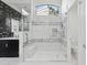 Modern bathroom featuring a glass shower with marble tile surround and sleek black and white design at 5403 E Cannon Dr, Paradise Valley, AZ 85253