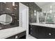 Contemporary bathroom with dual sinks, custom storage and black and white tile design at 5403 E Cannon Dr, Paradise Valley, AZ 85253