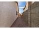 Gravel pathway leads to gated backyard access between block walls at 6632 E Fairbrook Cir, Mesa, AZ 85205