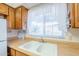 Bright kitchen featuring white double sink, wood cabinets, and built-in microwave at 867 N Arroya Rd, Apache Junction, AZ 85119