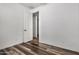 Simple bedroom with neutral tones, wood-look floors, and an open door at 9317 E Static Ave, Mesa, AZ 85212
