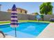 Refreshing pool with striped patio umbrella at 941 W Dexter Way, San Tan Valley, AZ 85143