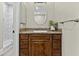 Bathroom with dark wood cabinet with granite countertop, oval mirror, and marble shower at 9437 W Avenida Del Sol Ave, Peoria, AZ 85383