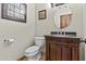 Bathroom with dark wood cabinet with granite countertop and oval mirror at 9437 W Avenida Del Sol Ave, Peoria, AZ 85383