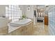 Luxurious bathroom features a standalone soaking tub and decorative glass block window at 9437 W Avenida Del Sol Ave, Peoria, AZ 85383