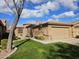 Tan stucco house with a two-car garage and landscaped front yard at 9610 E Rocky Lake Dr, Sun Lakes, AZ 85248