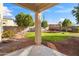 Backyard with covered patio, grassy area, and fire pit at 9931 W Odeum Ln, Tolleson, AZ 85353
