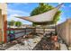 Backyard patio area with shade sail at 9931 W Odeum Ln, Tolleson, AZ 85353