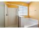 Bathroom with shower and tub, and a block window at 9931 W Odeum Ln, Tolleson, AZ 85353
