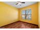 Bedroom with yellow walls and wood-look flooring at 9931 W Odeum Ln, Tolleson, AZ 85353