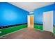 Bright bedroom with blue walls, green border, and carpet flooring at 9931 W Odeum Ln, Tolleson, AZ 85353