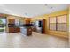 Open kitchen with island, dark countertops, and wooden cabinets at 9931 W Odeum Ln, Tolleson, AZ 85353