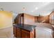 Open kitchen with island, dark countertops, and wooden cabinets at 9931 W Odeum Ln, Tolleson, AZ 85353