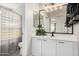 Modern bathroom with white vanity, new fixtures and striped shower curtain at 10103 E Olla Ave, Mesa, AZ 85212