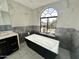 Modern bathroom showcasing a sleek black tub under an arched window, accented by marble tiling at 10113 E Topaz Dr, Scottsdale, AZ 85258