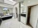 Elegant bathroom with a soaking tub, arched doorway, and a marble-tiled floor at 10113 E Topaz Dr, Scottsdale, AZ 85258