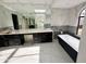 Bright bathroom featuring a long vanity with a marble countertop, large mirror, and sleek bathtub at 10113 E Topaz Dr, Scottsdale, AZ 85258