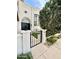 Charming front entrance with a black wrought iron gate, lush greenery, and a black door at 10113 E Topaz Dr, Scottsdale, AZ 85258