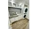 Practical laundry room with a stacked washer/dryer, stylish backsplash, and counter space at 10113 E Topaz Dr, Scottsdale, AZ 85258