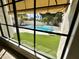 A view through a window to the outdoor pool and patio area in this backyard oasis at 10113 E Topaz Dr, Scottsdale, AZ 85258