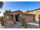 Front view of a tan house with cacti and a two-car garage at 1133 E Dust Devil Dr, San Tan Valley, AZ 85143