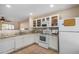 White kitchen with granite countertops and stainless steel appliances at 1133 E Dust Devil Dr, San Tan Valley, AZ 85143