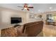 Living room with a brown couch, TV, and dining area at 1133 E Dust Devil Dr, San Tan Valley, AZ 85143