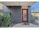 Condo entry with red door, gray walls, and small courtyard view at 1241 E Medlock Dr # 110, Phoenix, AZ 85014