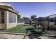 Landscaped backyard with artificial turf, two chairs, and a fenced perimeter at 147 S Los Cielos Ln, Casa Grande, AZ 85194