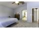 Bright bedroom featuring a ceiling fan, dresser, and glimpse into a walk-in closet at 147 S Los Cielos Ln, Casa Grande, AZ 85194