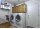 Laundry room with washer, dryer, and overhead cabinets at 147 S Los Cielos Ln, Casa Grande, AZ 85194