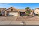 Tan house with a two-car garage and drought-tolerant landscaping at 15220 W Blue Verde Dr, Sun City West, AZ 85375