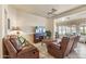 Relaxing living room featuring brown leather reclining chairs and a large TV at 15220 W Blue Verde Dr, Sun City West, AZ 85375