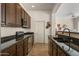 Kitchen with dark wood cabinets, granite counters and a large sink at 15240 N 142Nd Ave # 2159, Surprise, AZ 85379