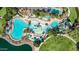 Aerial view of a large community pool area, featuring slides, various pools, and many seating options at 18187 W Wind Song Ave, Goodyear, AZ 85338