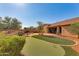 Landscaped backyard with putting green and covered patio at 18187 W Wind Song Ave, Goodyear, AZ 85338