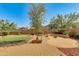 Landscaped backyard with a fire pit and putting green at 18187 W Wind Song Ave, Goodyear, AZ 85338