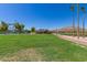 Expansive green area with a lake and sport courts at 18187 W Wind Song Ave, Goodyear, AZ 85338