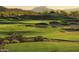 Scenic view of a lush green golf course with sand traps and rolling hillsides at 18187 W Wind Song Ave, Goodyear, AZ 85338