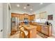 Modern kitchen with island, stainless steel appliances, and wood cabinets at 18187 W Wind Song Ave, Goodyear, AZ 85338