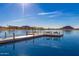 Wooden dock extending into a calm lake with scenic background at 18187 W Wind Song Ave, Goodyear, AZ 85338