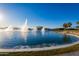 Water fountains in a tranquil lake setting with palm trees at 18187 W Wind Song Ave, Goodyear, AZ 85338