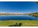 Serene lake view with reflection of homes and clouds at 18187 W Wind Song Ave, Goodyear, AZ 85338